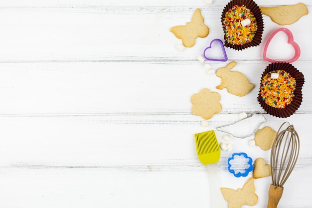 Free Photo animal shaped cookies with kitchen utensils on wooden table