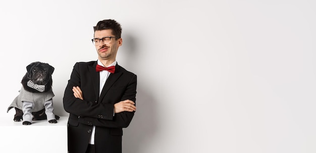 Free photo animals party and celebration concept image of funny young man in suit and glasses looking skeptical