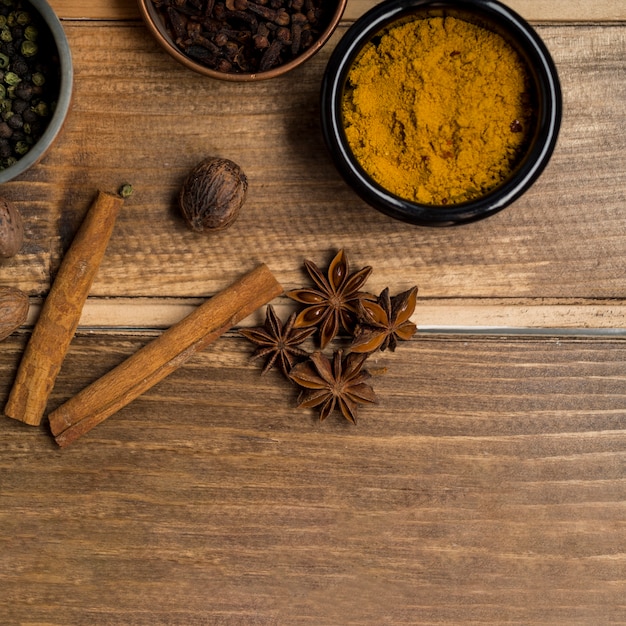 Free photo anise and cinnamon near bowls with spices