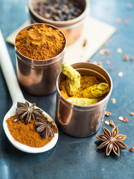 Free photo anise near spoon and tins with spices