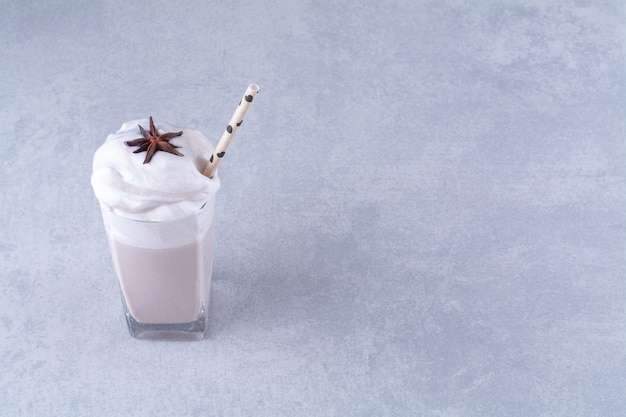 Free Photo anise star on a glass of tasty milkshake with straw on marble table.