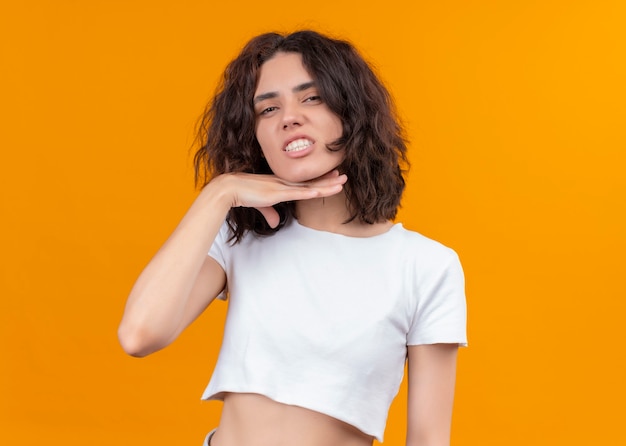 Annoyed young beautiful woman putting hand under her chin on isolated orange wall with copy space