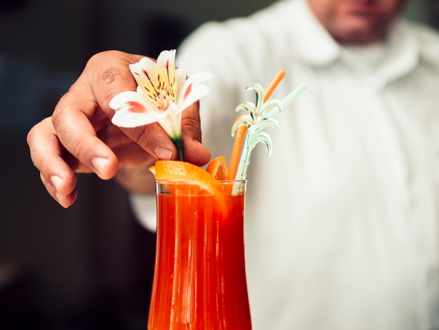 Free photo anonymous bartender serving refreshing drink in glass