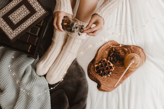 Anonymous female with acorns near book and snacks