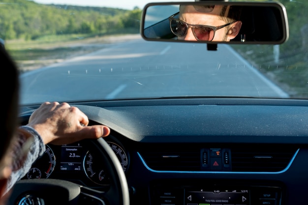 Free photo anonymous male traveling with car on sunny day