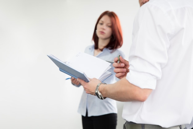 Free photo anonymous man with notebook among colleagues