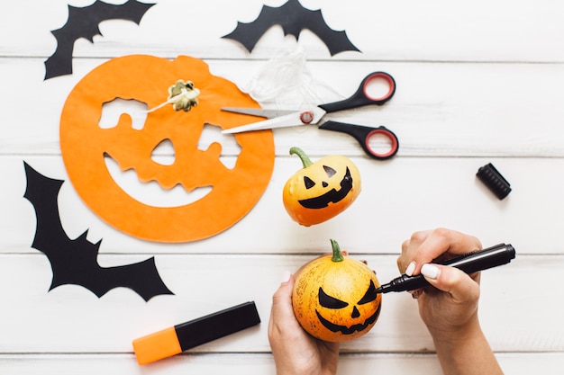 Free Photo anonymous woman creating pumpkins for halloween