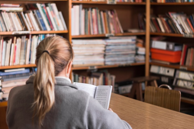 Anonymous woman reading in library