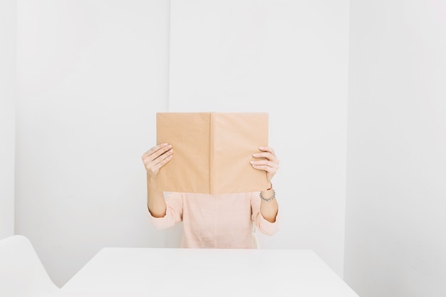 Free photo anonymous woman reading at table