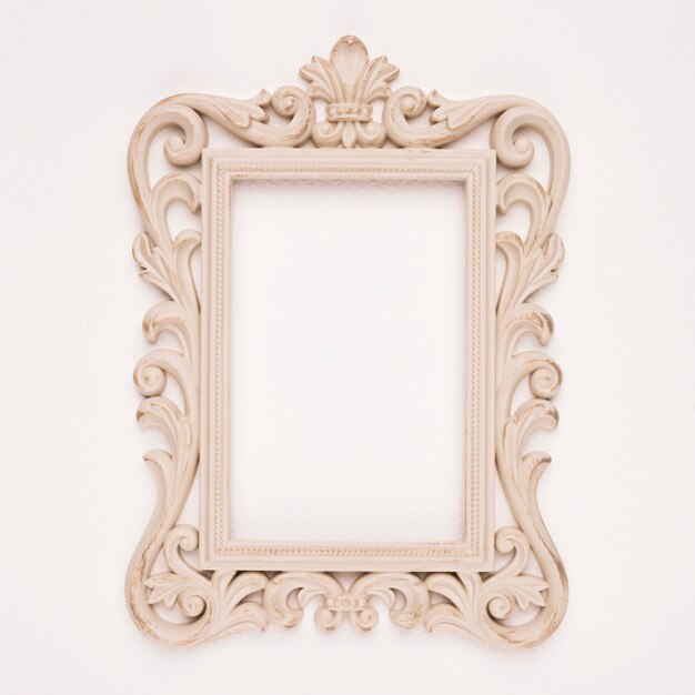 Antique gilded wooden frame on beige backdrop