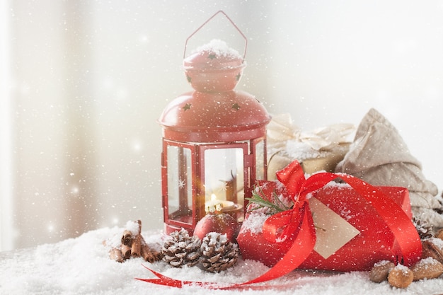 Antique lamp with a red gift while it snows