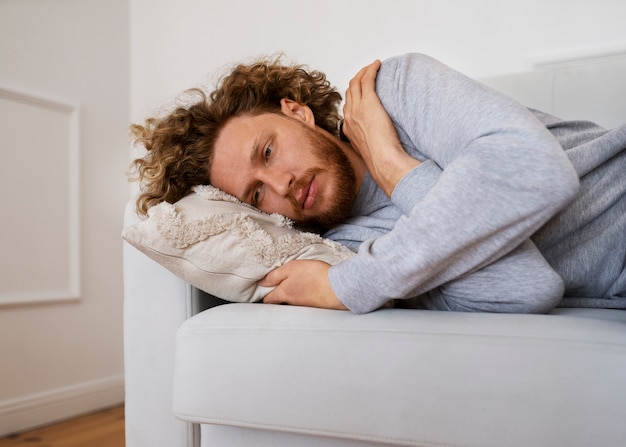 Free Photo anxious man laying on couch medium shot