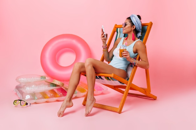 Appealing woman in swimsuit sitting in deck chair