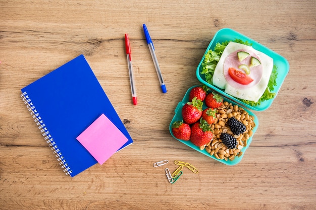 Appetizing school lunch and stationery on table