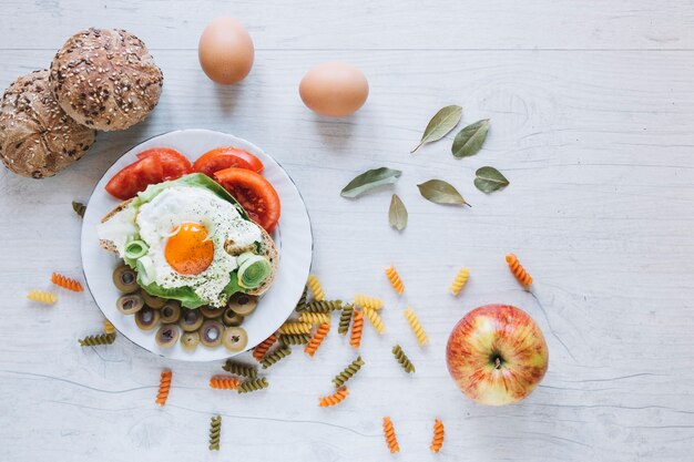 Apple and buns near fried egg