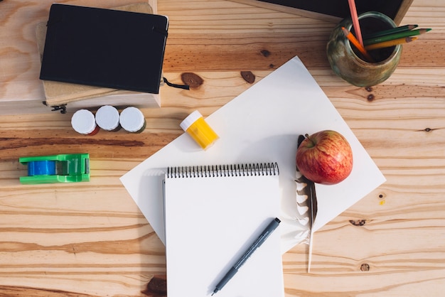 Free photo apple and feather near drawing supplies