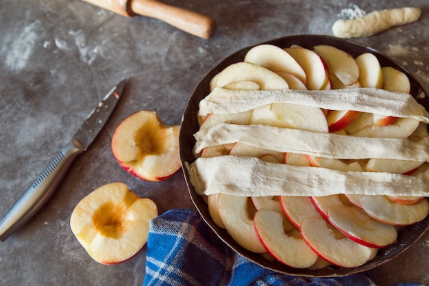 Apple pie with halved fruit on table