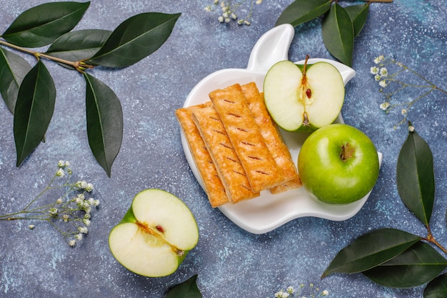 Apple puff pastry cookies in apple shape plate with fresh apples