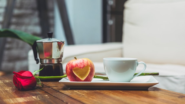 Apple with cut out heart shape on table