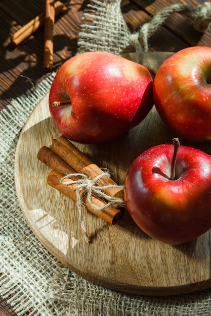 Free Photo apples with cinnamon sticks on cutting board