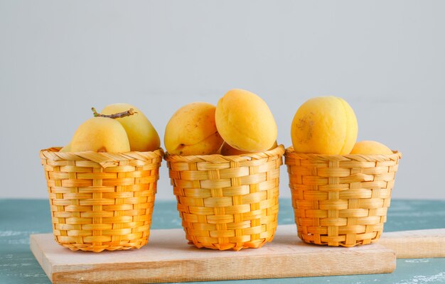 Apricots with cutting board in baskets