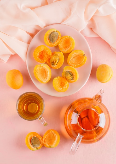 Free photo apricots with tea in a plate, top view.