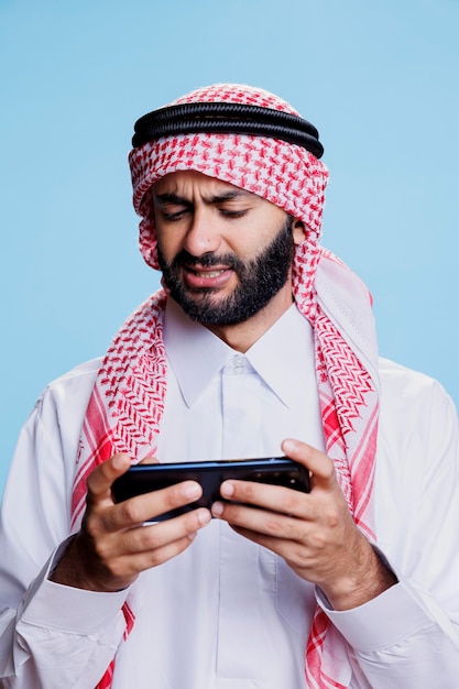 Free Photo arab playing videogame on smartphone