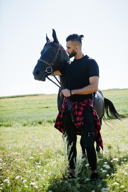 Free photo arab tall beard man wear in black with arabian horse