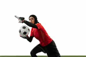 Free photo arabian female soccer or football player, goalkeeper on white studio background. young woman giving pass, emotional gesturing, protecting goals for team. concept of sport, hobby, healthy lifestyle.