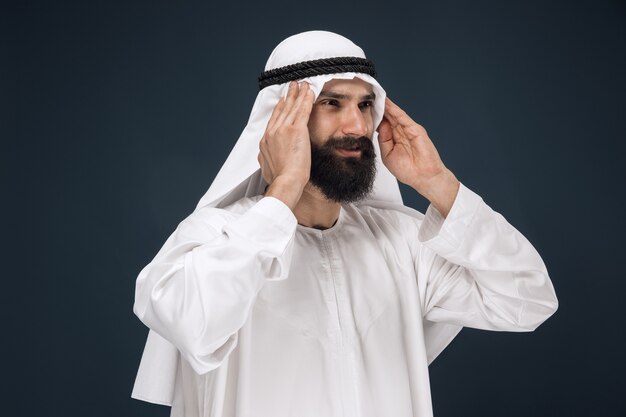 Arabian saudi man on dark blue studio background