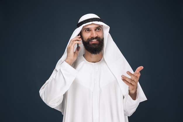 Arabian saudi man on dark blue studio background