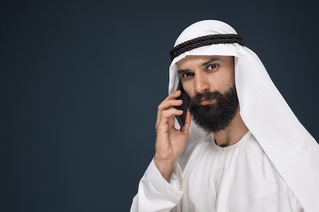 Free Photo arabian saudi man on dark blue studio background