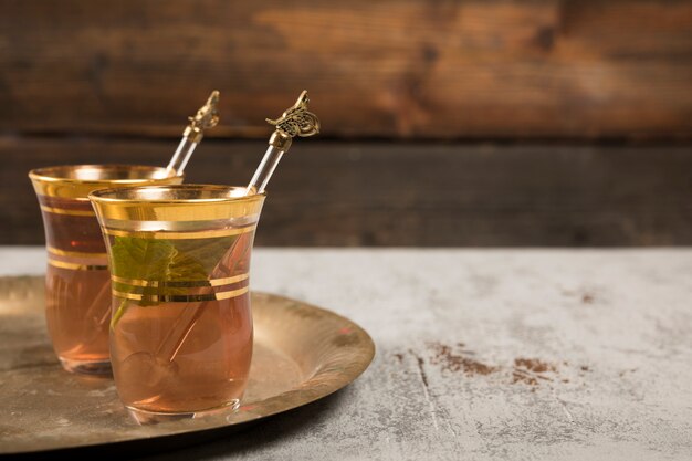 Arabic tea in glasses with green mint on tray