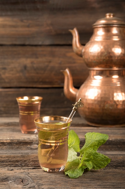 Arabic tea in glasses with teapots on table