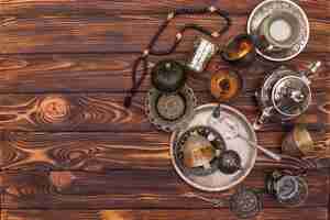 Free photo arabic teapot with cups and beads on table