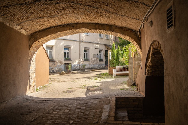 Free Photo arched building surrounded by apartments and greenery under the sunlight during daytime