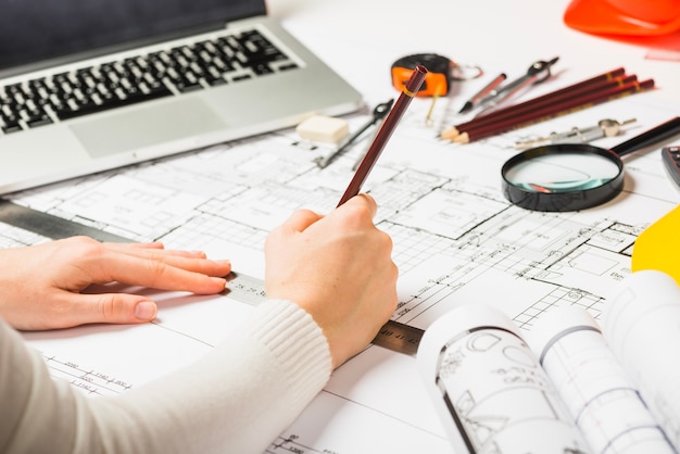 Free photo architect drawing blueprint with pencil