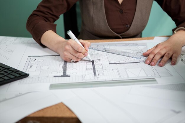 Architect working on blueprints on her desk. Working on new projects. Architecture and design