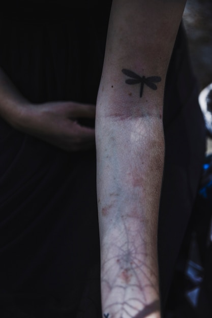 Free photo arm of woman with dragonfly tattoo