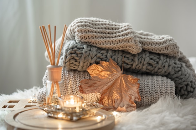 Free photo aroma bamboo sticks in a bottle with scented liquid with candles staying on a wooden tray on blurred background.