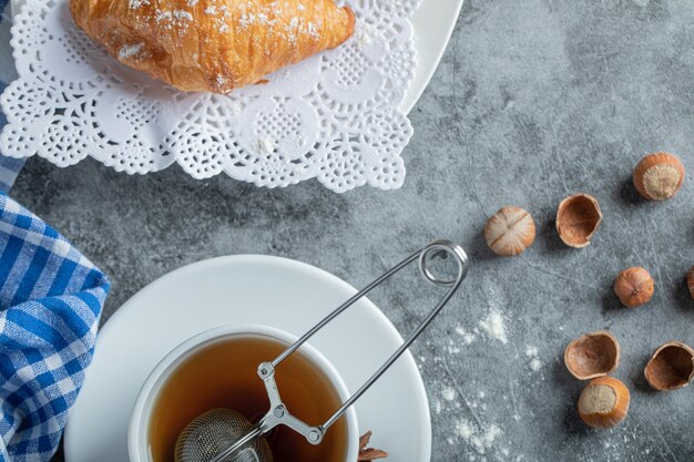 Aroma cup of tea with delicious croissants.