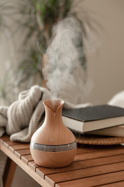 Aroma oil diffuser lamp on a blurred background in the interior of the room