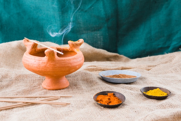 Free photo aroma sticks on bowl near saucers with different spices