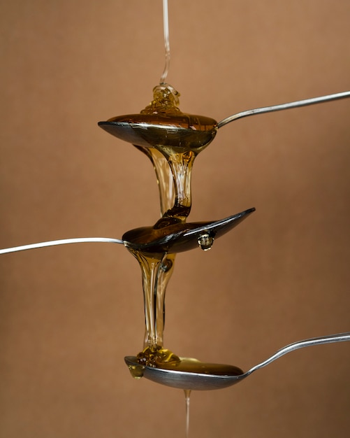 Free photo aromatic honey pouring on spoons