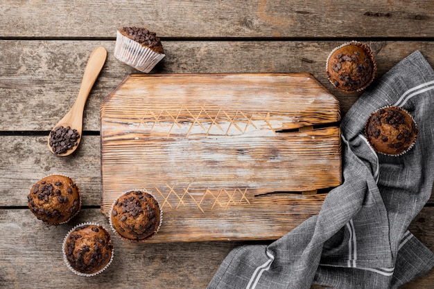 Free photo arrangement of baked muffins and wooden board