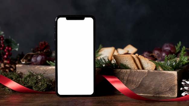 Arrangement of christmas food with empty smartphone