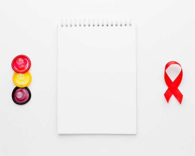 Free photo arrangement of colorful condoms with empty notepad