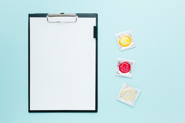 Arrangement of contraception concept on blue background with empty clipboard