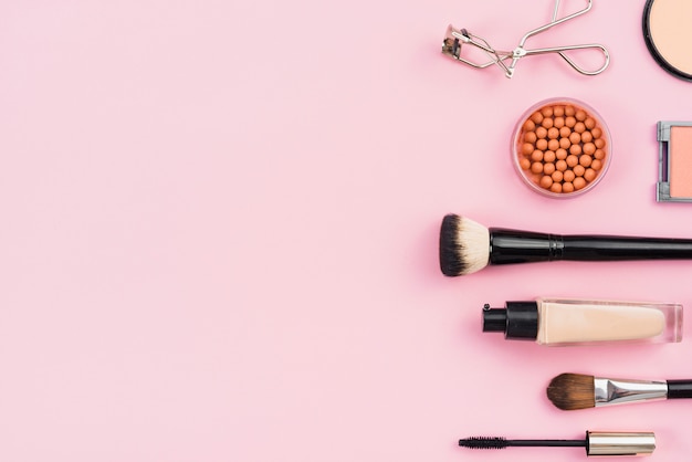 Free photo arrangement of makeup products on pink background