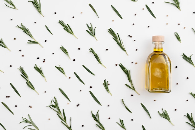 Free photo arrangement of olive leaves with oil in bottle